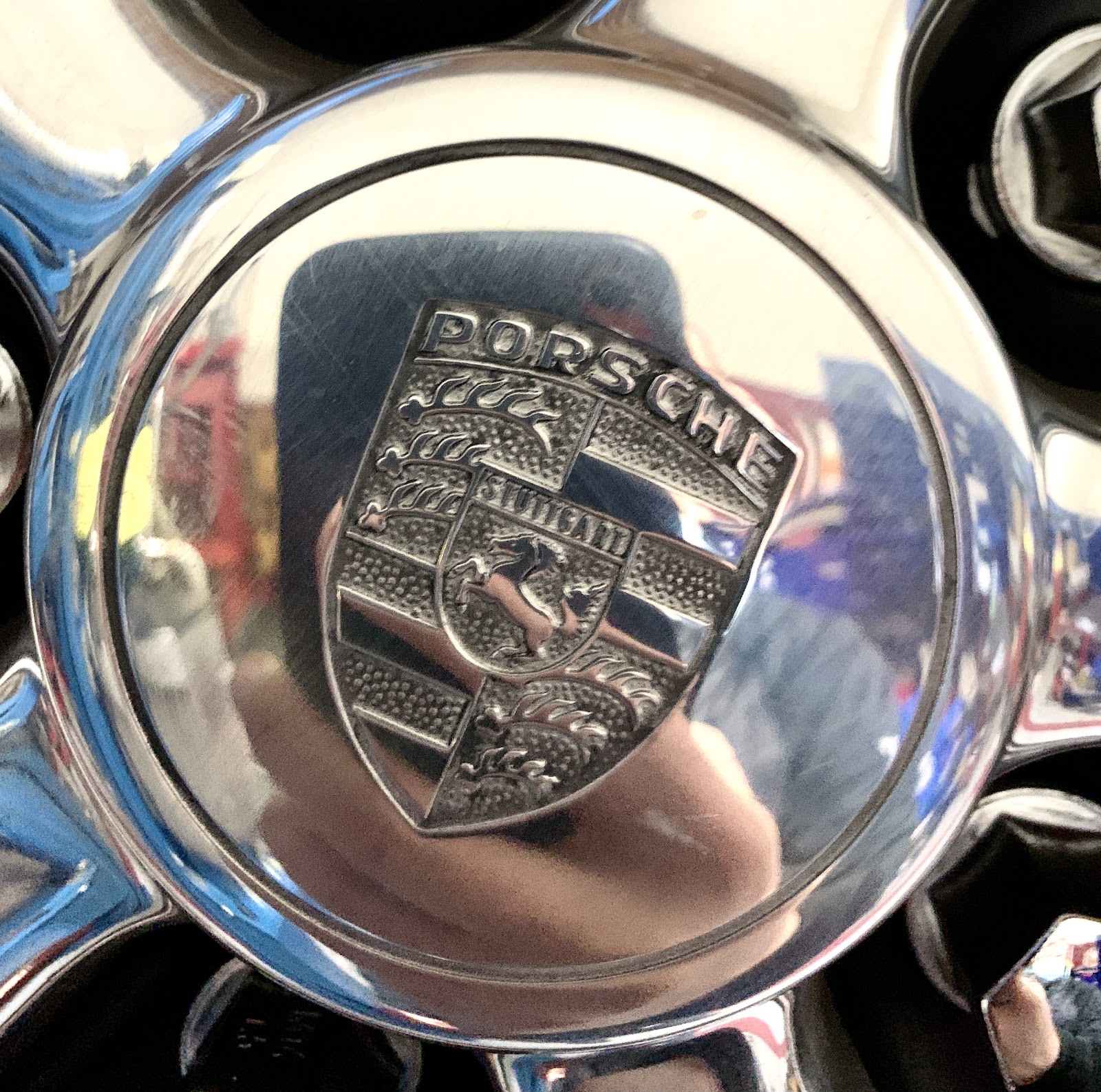 Close detail of a polished Porsche Fuchs wheel centre cap.